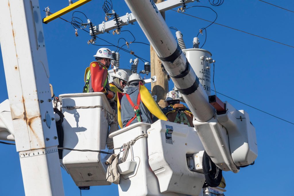 Photo: Electrical linemen, working for DTE Energy, replace transmission equipment on an electrical pole in Detroit, Michigan. Credit: Jim West / Alamy Stock Photo