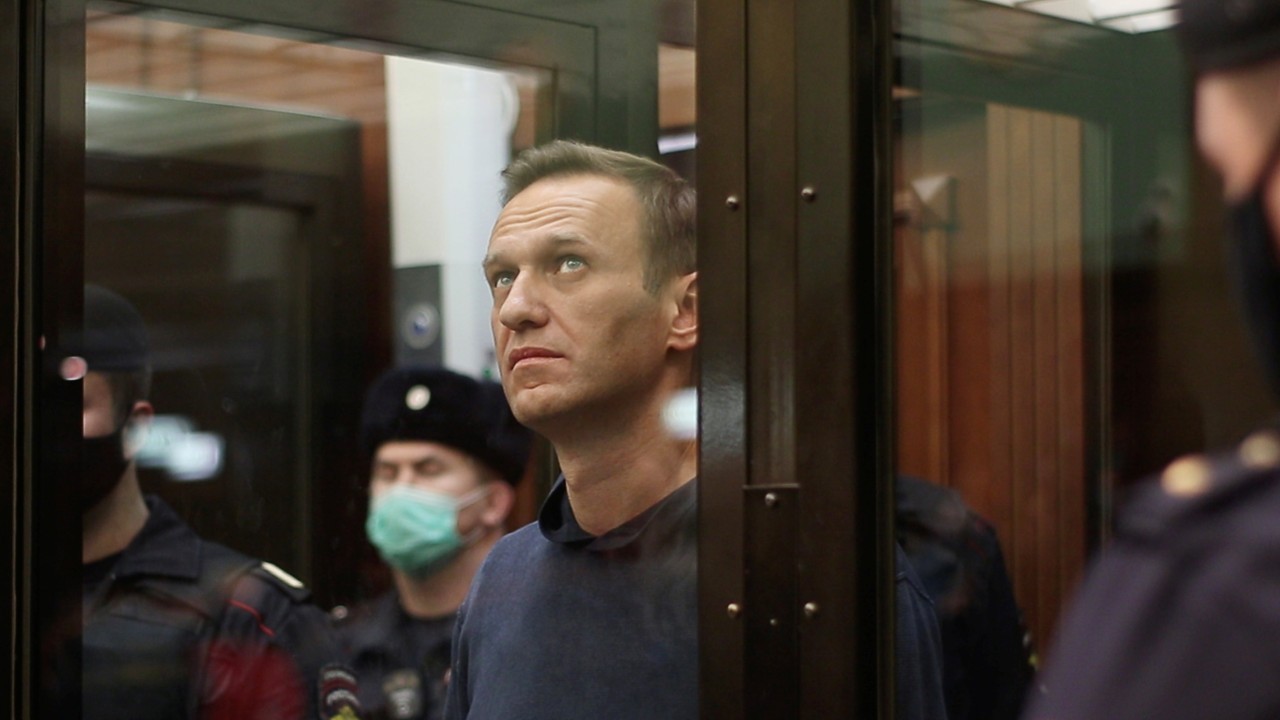 A still image taken from video footage shows Russian opposition leader Alexei Navalny, who is accused of flouting the terms of a suspended sentence for embezzlement, inside a defendant dock during the announcement of a court verdict in Moscow, Russia February 2, 2021. Press service of Simonovsky District Court/Handout