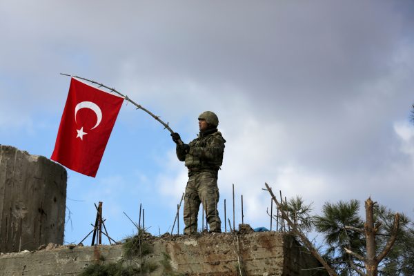 Photo: A Turkish soldier waves a flag on Mount Barsaya, northeast of Afrin, Syria January 28 ,2018. Credit: REUTERS/ Khalil Ashawi/File Photo