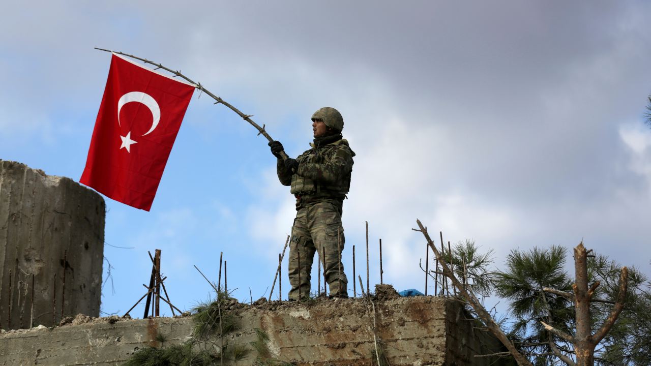 Photo: A Turkish soldier waves a flag on Mount Barsaya, northeast of Afrin, Syria January 28 ,2018. Credit: REUTERS/ Khalil Ashawi/File Photo