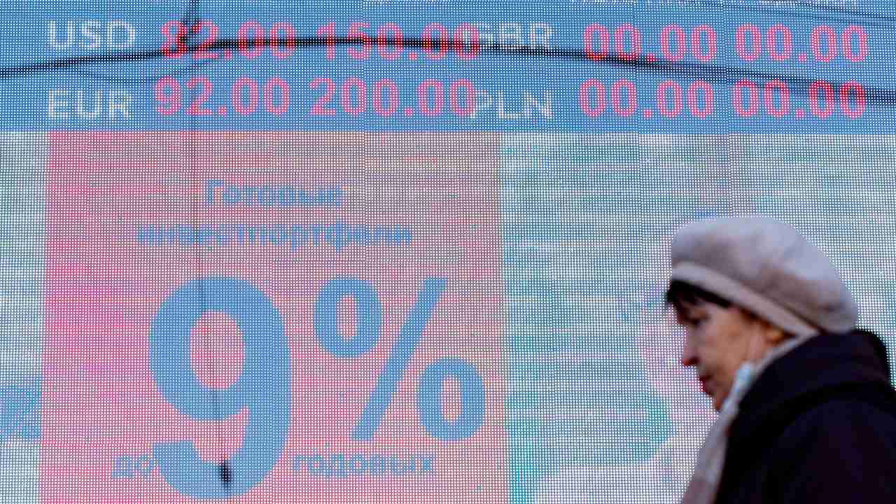 Photo: KALININGRAD, RUSSIA - FEBRUARY 24, 2022: A woman walks past a digital board displaying the current rates outside a currency exchange office. As of 10am, the Moscow Exchange has reported the US dollar and Euro trading at 89.6 and 99.99 respectively against the Russian rouble, thus reaching their historic highs. Credit: Vitaly Nevar/TASS.