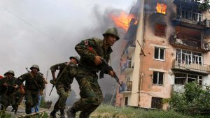 Photo: Georgian soldiers run near a blazing building after a Russian bombardment in Gori, 80 km (50 miles) from Tbilisi, August 9, 2008. A Russian warplane dropped a bomb on an apartment block in the Georgian town of Gori on Saturday, killing at least 5 people, a Reuters reporter said. The bomb hit the five-story building in Gori close to Georgia's embattled breakaway province of South Ossetia when Russian warplanes carried out a raid against military targets around the town. Credit: REUTERS/Gleb Garanich (GEORGIA)