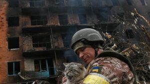 Photo: A Ukrainian service member holds a stray cat in front of a heavily damaged apartment building in the town of Valsylkiv, where local authorities say two Russian Smerch missiles landed causing a yet unknown number of fatalities and casualties. Rescue efforts by first responders and Ukrainian military continue through the day. Vasylkiv, Ukraine, March 1st, 2022. Credit: Justin Yau/ Sipa USA