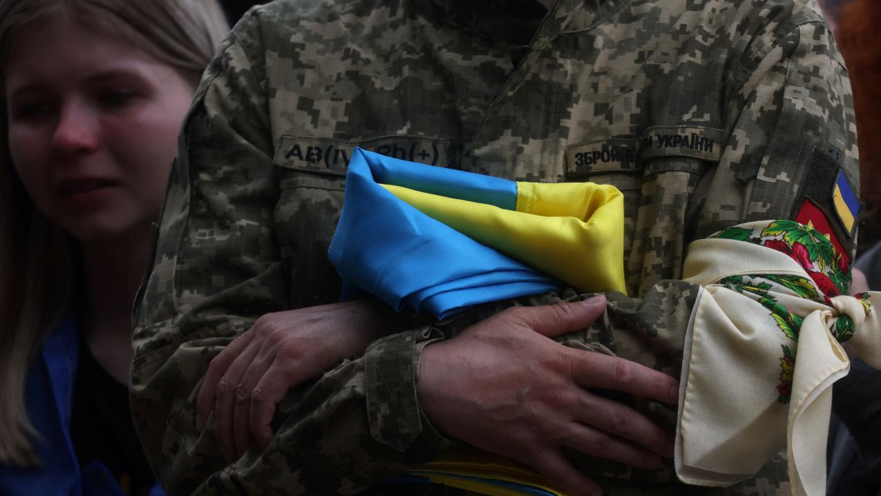 Photo: Taras Ratushnyi, the father of soldier Roman Ratushnyi, a well-known activist, holds his Ukrainian flag as he and friends, family, fellow soldiers and others attend Roman's burial service in Kyiv, Ukraine, as Russia's attack on Ukraine continues June 18, 2022. Credit: REUTERS/Leah Millis