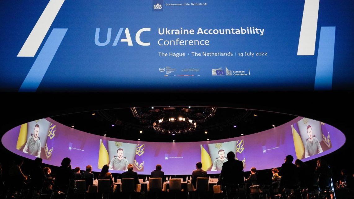 Photo: Ukrainian President Volodymyr Zelensky speaks to conference participants via video link at the Ukraine Accountability Conference. Credit: Dutch Ministry of Foreign Affairs via Flickr