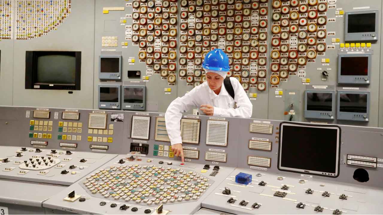 Photo: Tour guide Jurgita Norvaisiene points at a red button in the central control room during a guided tour in decommissioned Ignalina nuclear power station in Visaginas, Lithuania July 24, 2019. Picture taken July 24, 2019. Credit: REUTERS/Ints Kalnins.