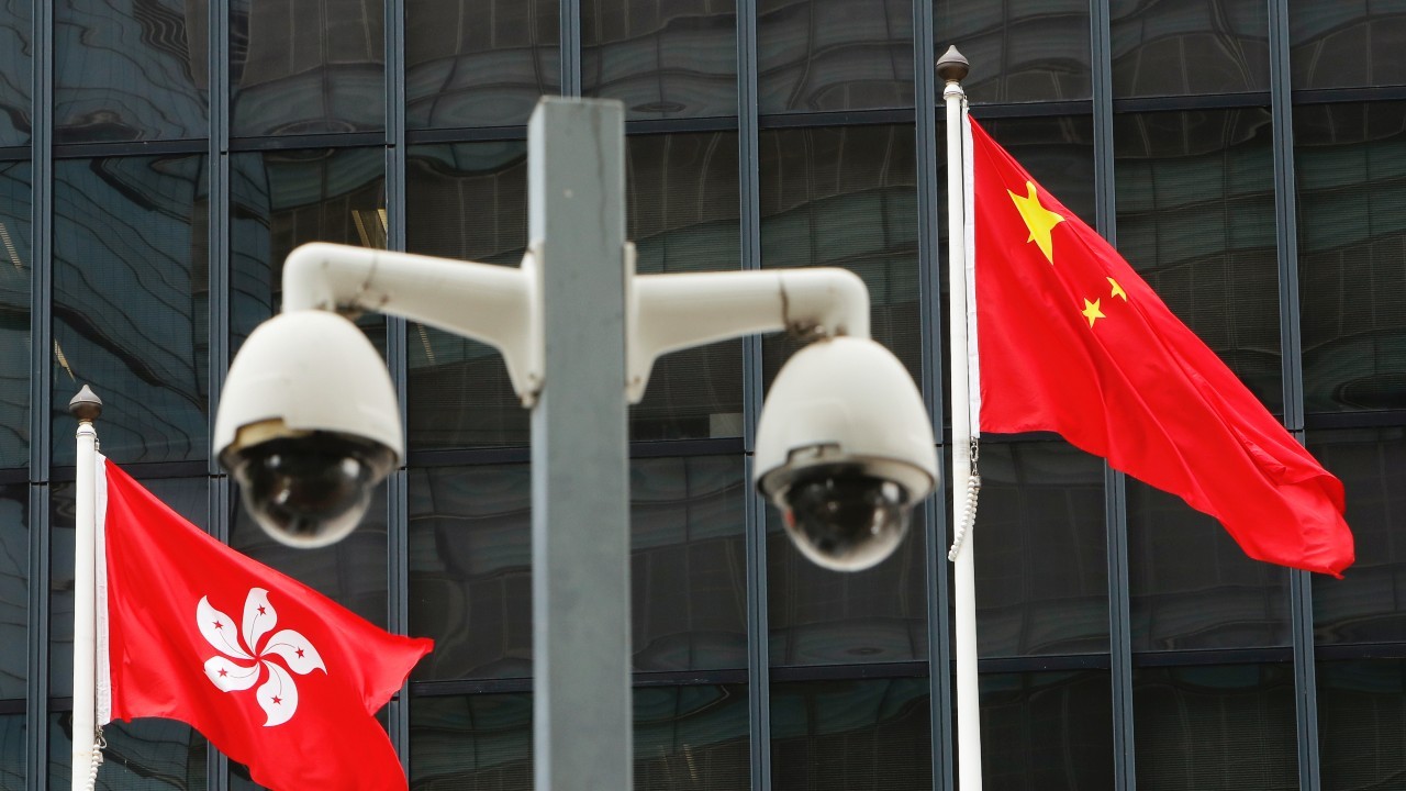 Photo: Hong Kong and Chinese national flags are flown behind a pair of surveillance cameras outside the Central Government Offices in Hong Kong, China July 20, 2020. Credit: REUTERS/Tyrone Siu