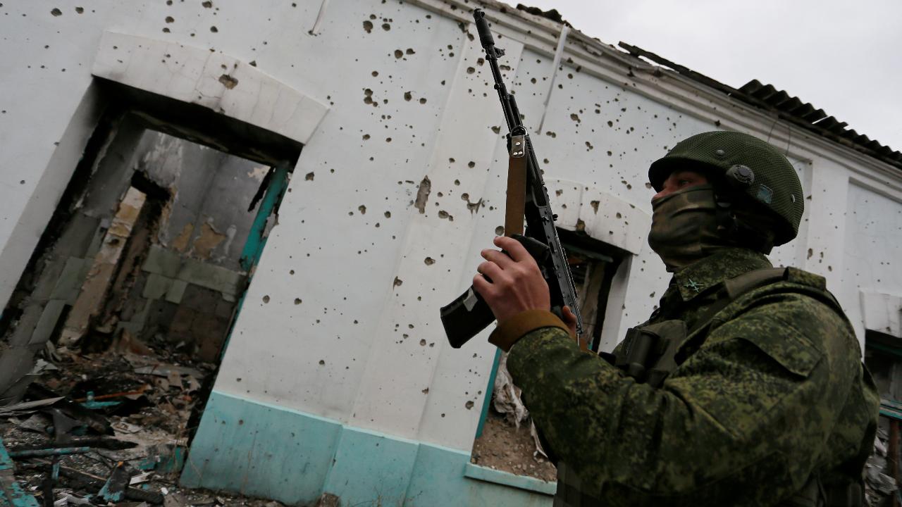 Photo: A militant of the self-proclaimed Luhansk People's Republic (LNR) holds a weapon at fighting positions on the line of separation from the Ukrainian armed forces in Luhansk Region, Ukraine April 13, 2021. Credit: REUTERS/Alexander Ermochenko