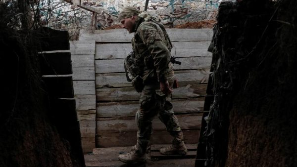 Photo: A Ukrainian service member walks along a trench on the front line near the village of Travneve in Donetsk region, Ukraine, December 15, 2021. Picture taken December 15, 2021. Credit: REUTERS/Gleb Garanich