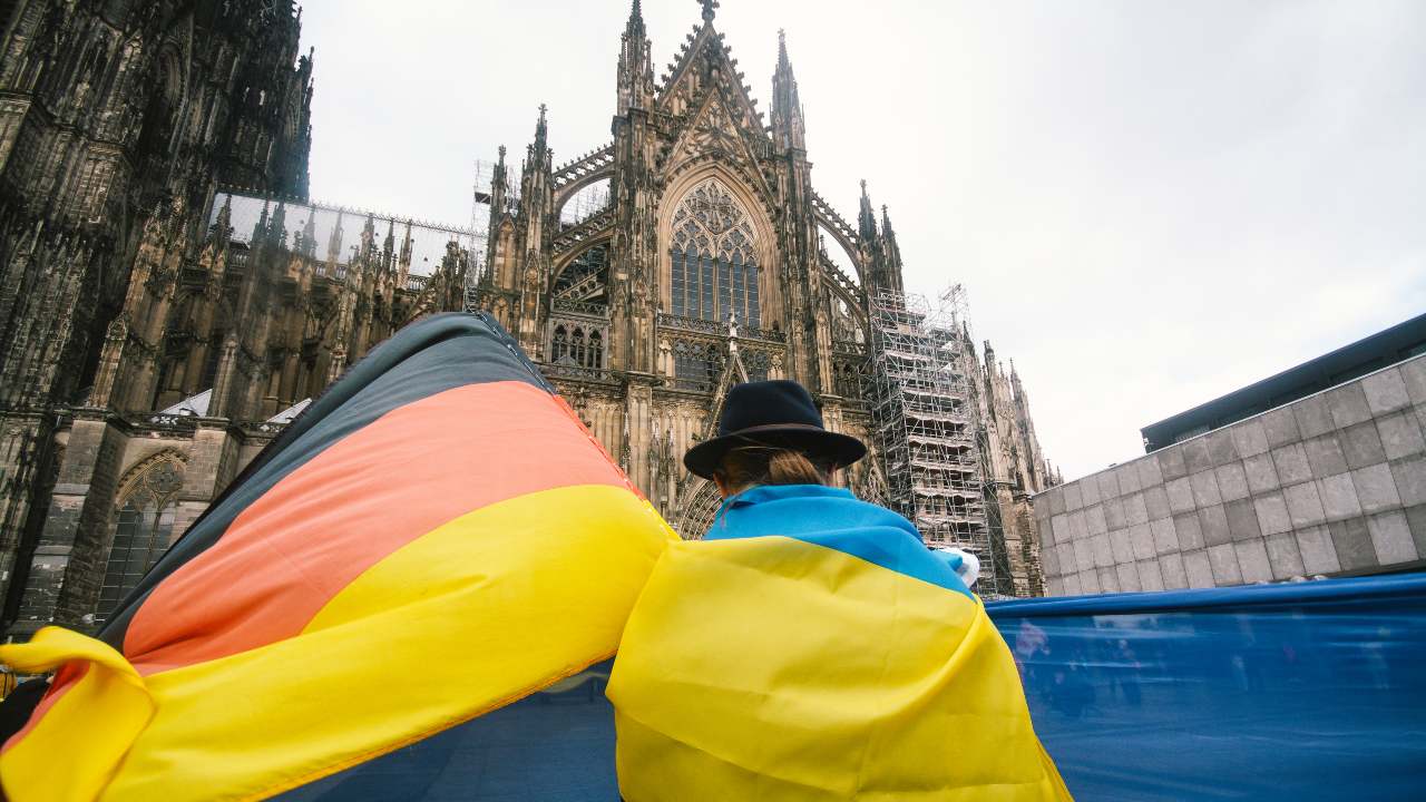 Photo: A woman with a Ukraine flag and German flag during a protest in Cologne, Germany, on January 30, 2022. - Demonstrators criticised Putin's massing of troops near the Ukrainian border and called on Germany to play a more active role in defending Ukraine's interests. Credit: Ying Tang/NurPhoto