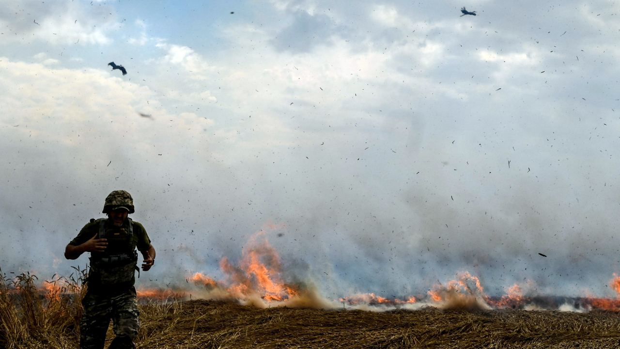 Photo: ZAPORIZHZHIA REGION, UKRAINE - JULY 17, 2022 - A man in a military uniform stays in a burning wheat field as Russian troops shell fields to prevent local farmers from harvesting grain crops, Polohy district, Zaporizhzhia Region, southeastern Ukraine. Credit: Dmytro Smolyenko via Reuters Connect