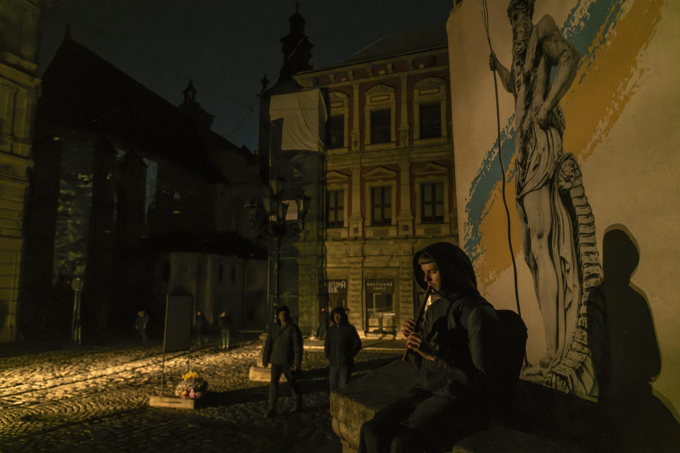 Photo: The person plays on the flute in the center of Lviv during a blackout after a massive Russian missile attack on Ukrainian power infrastructure, Ukraine, November 15, 2022 Credit: Photo by Maxym Marusenko/NurPhoto