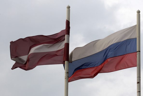 Photo: A Latvian (L) flag flutters in the wind next to a Russian flag near a hotel in Daugavpils March 21, 2014. In the former Soviet republics of Latvia and Estonia, there is unease over events in Crimea, which was formally annexed by Moscow last week on the pretext of safeguarding its Russian minorities. In the Latvian town of Daugavpils, where a Russian Tzarist-era fortress and barracks meet grey Soviet-era apartment blocks, you are more likely to be greeted in Russian than Latvian, with 51 percent of the city's residents being Russians. Credit: Picture taken March 21, 2014. To match Insight UKRAINE-CRISIS/RUSSIA REUTERS/Ints Kalnins.