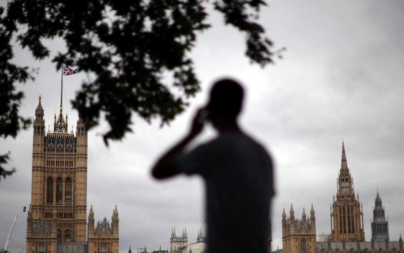 Photo: A man talks on his mobile phone in front of the Houses of Parliament in London, Britain, August 17, 2021. Credit: REUTERS/Hannah McKay