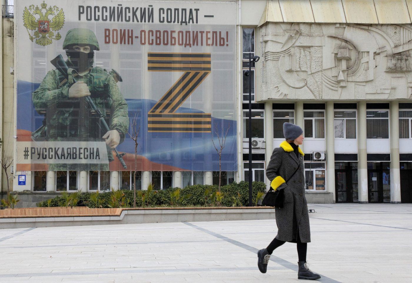 Photo: A pedestrian walks near a banner, which displays the symbol "Z" in support of the Russian armed forces involved in the country's military campaign in Ukraine, in Yalta, Crimea, February 8, 2023. One of the slogans on the banner reads: "Russian soldier is warrior-liberator!" Credit: REUTERS/Alexey Pavlishak