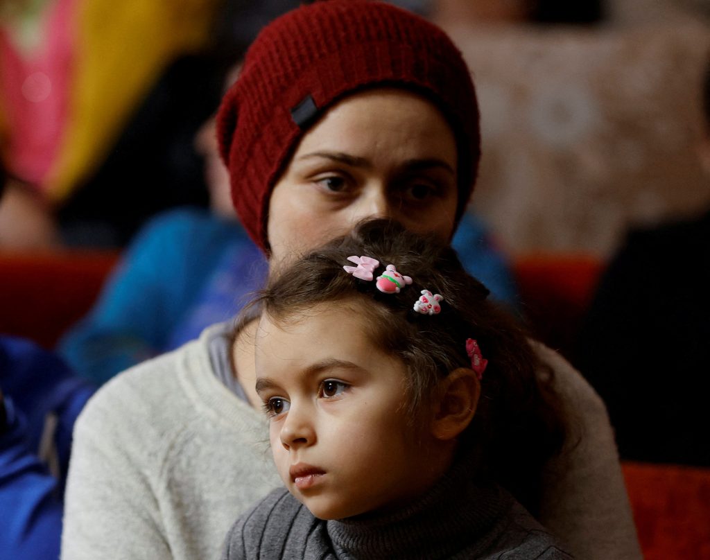 Photo: Yelena Vyacheslavskaya, 35, and her daughter Kira, 7, evacuated from Bakhmut district in the course of Russia-Ukraine conflict, attend a meeting with Denis Pushilin, Moscow-installed acting leader of the Russian-controlled parts of Ukraine's Donetsk region, at a temporary accommodation centre in a local dormitory in Shakhtarsk (Shakhtyorsk) in the Donetsk Region, Russian-controlled Ukraine, March 2, 2023. Credit: REUTERS/Alexander Ermochenko 