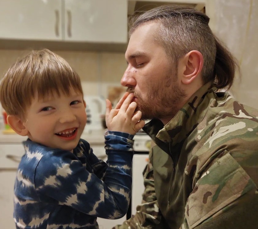 Photo: Igor Slayko kissing his son’s hands during a short stay at home in Kyiv. Credit: Courtesy of Olena Kozachenko 