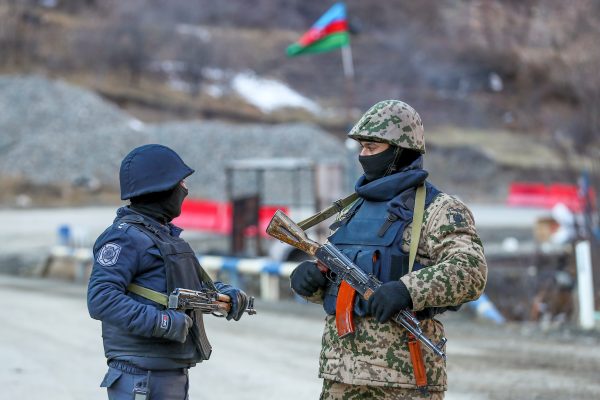 Photo: An Azeri soldier and police officer talk as they stand guard at the Kalbajar district, Azerbaijan, December 21, 2020. Picture taken December 21, 2020. Credit: REUTERS/Aziz Karimov