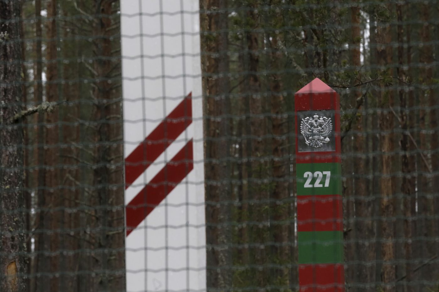 Photo: Latvian and Russian border signs are pictured behind a newly built fence at the Latvian-Russian border near Goliseva, Latvia, April 26, 2016. Credit: REUTERS/Ints Kalnins