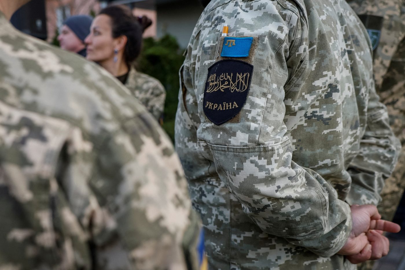 Photo: A Muslim soldier wears patches with the Shahada, an Islamic oath and the Flag of the Crimean Tatar people, as they attend an Iftar where Ukrainian President Volodymyr Zelenskiy will share a meal with Ukrainian Muslim soldiers, breaking their fast, during the holy fasting month of Ramadan, near a mosque in the outskirts of Kyiv, Ukraine, April 7, 2023. Credit: REUTERS/Alina Smutko.