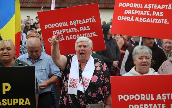 Photo: Supporters of Moldova's opposition pro-Russian political party Shor attend a rally before a hearing of the Constitutional Court held to verify the constitutionality of the party in Chisinau, Moldova, June 19, 2023. A slogan on boards reads: "People are waiting for justice, PAS (party) proposes lawlessness". Credit: REUTERS/Vladislav Culiomza
