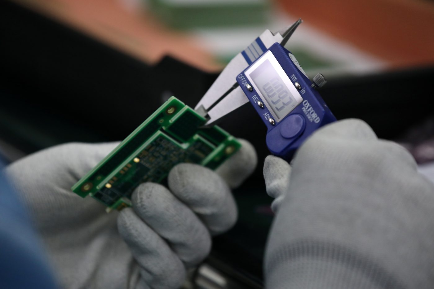 Photo: An employee of the automated test equipment designer and solutions provider Aemulus Holdings Berhad inspects a printed circuit board at a production facility in Penang, Malaysia, September 20, 2019. Picture taken September 20, 2019. Credit: REUTERS/Lim Huey Teng