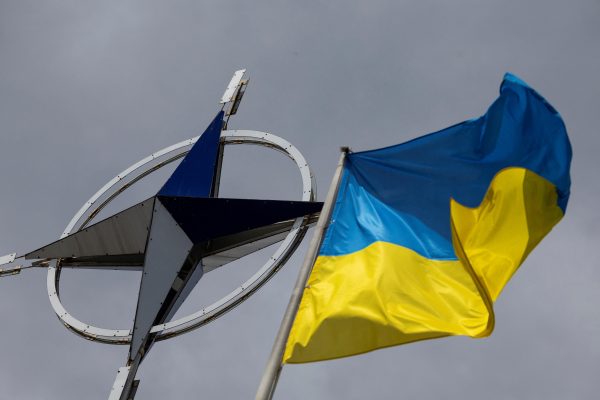 Photo: A Ukrainian national flag rises in front of the NATO emblem, amid Russia's attack on Ukraine, in central Kyiv, Ukraine July 11, 2023. Credit: REUTERS/Valentyn Ogirenko