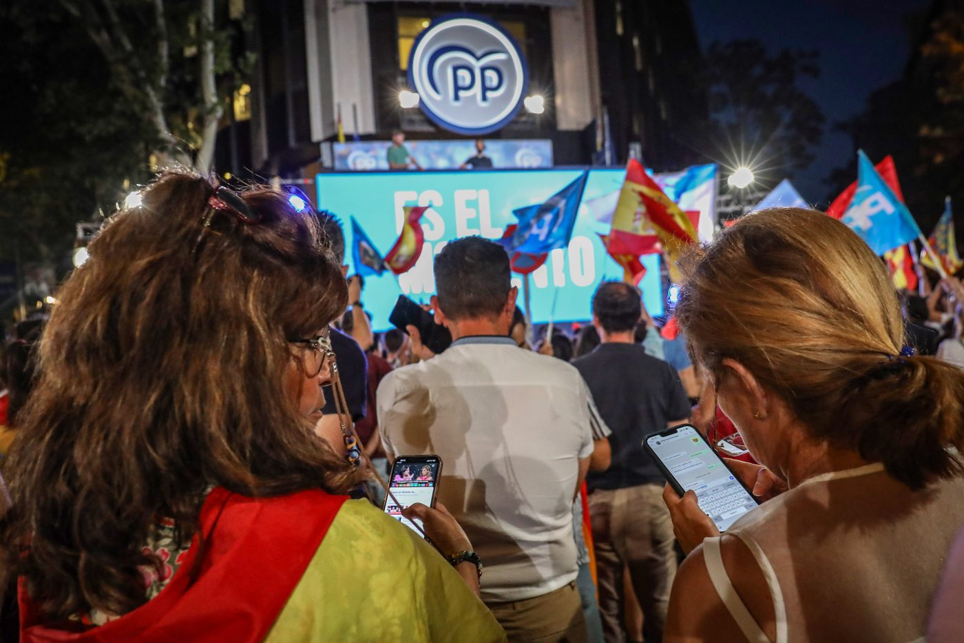 Photo: Supporters of the Popular Party consult the results of the elections on their mobile phones while they wait for the vote to be counted at the Popular Party headquarters. Dozens of people gather at Calle Génova 13 at the gates of the headquarters of the Popular Party (PP) to await the results of the Spanish general elections, which the right-wing Spanish party won with 136 seats in Congress over 122 for the Spanish Socialist Workers Party (PSOE). Credit: David Canales / SOPA Images/Sipa USA