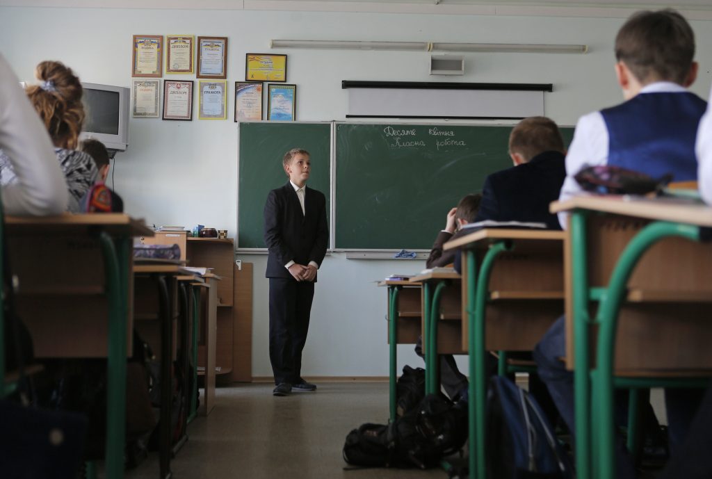 Photo: Pupils attend a lesson at a local school in Simferopol, April 10, 2014. Natalia Rudenko's ears were still ringing from being shouted at by a father demanding that the Ukrainian-language school she has run for 17 years in Crimea's capital now teach in Russian when local officials turned up at her office to dismiss her. Their message: Rudenko and her school dedicated to sending students to Ukrainian universities no longer have a place in a society that voted to secede from Ukraine and join Russia last month after Moscow deployed troops across the Black Sea peninsula. Since President Vladimir Putin formally annexed Crimea on March 21, confusion has reigned. Courts are paralysed, the banking network is in disarray as Ukrainian and Western banks pull out, and business ties with the mainland are sundered. Picture taken April 10, 2014. Credit: REUTERS/Maxim Shemetov