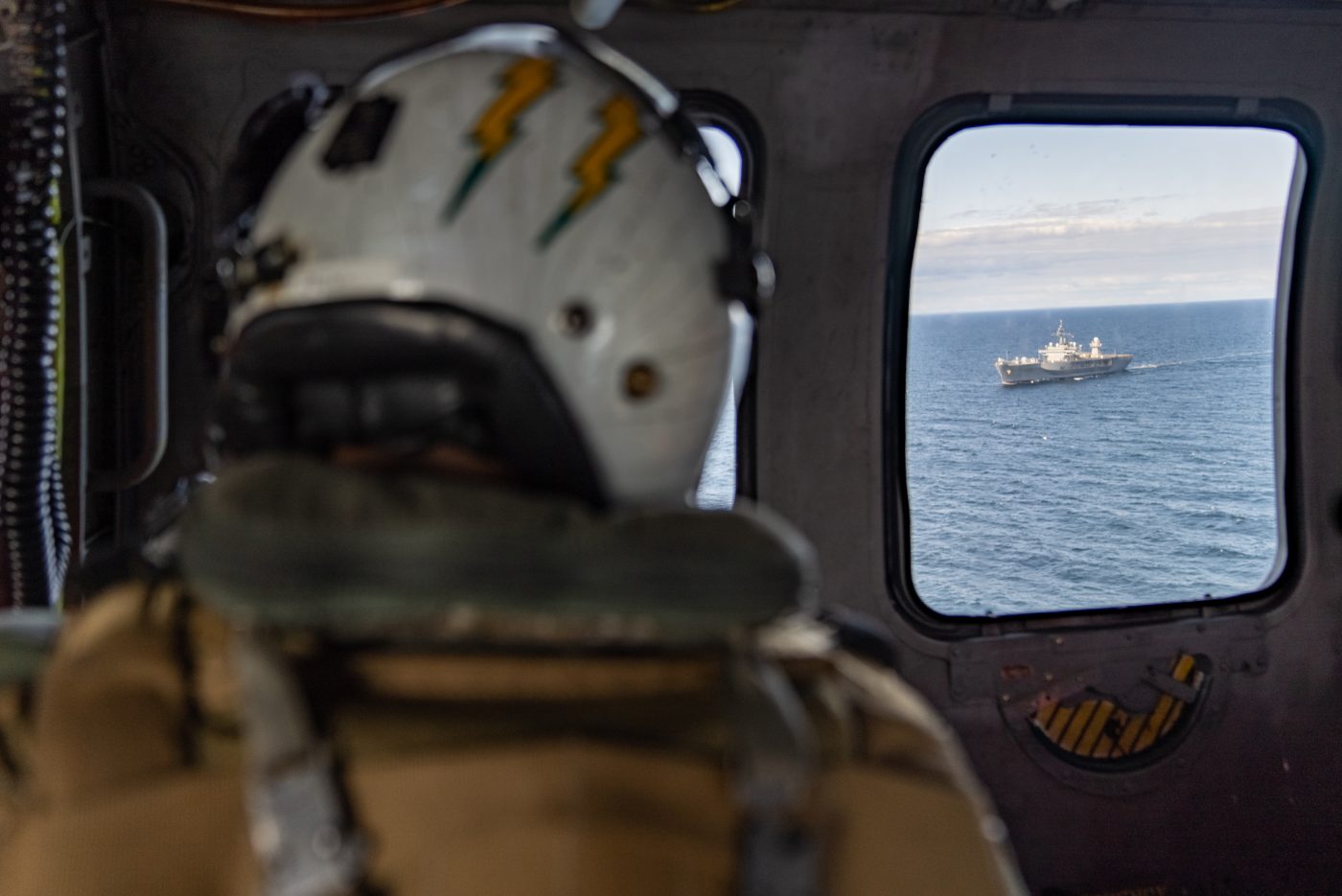 Photo: A US naval aircrewman looks out to USS Mount Whitney while airborne. Credit: NATO via Flickr https://flic.kr/p/2oGV12h