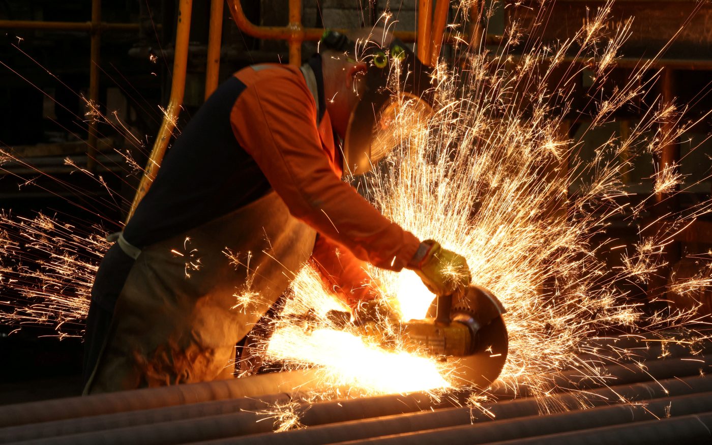 Photo: A worker cuts newly manufactured bars of steel at the United Cast Bar Group's foundry in Chesterfield, Britain, April 12, 2022. Picture taken April 12, 2022. Credit: REUTERS/Phil Noble