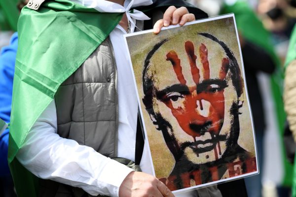 Photo: A poster of Russian president Vladimir Putin is pictured during a protest against re-election of Syria's President Bashar al-Assad, near Syria's embassy, Berlin, Germany May 26, 2021. Credit: REUTERS/Annegret Hilse