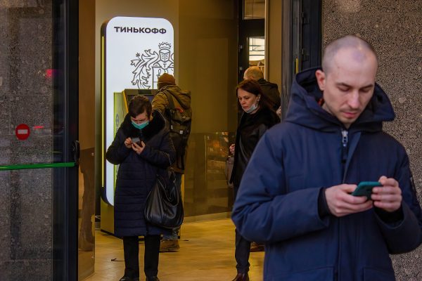 Photo: A man and a woman check Tinkoff app on their phones to find out where else could the U.S. dollars be available at ATMs in Moscow. Moments ago they unsuccessfully tried to withdraw the foreign currency from this ATM. The invasion of Ukraine by the Russian military has sent the Russian ruble plummeting, leading uneasy people to line up at banks and ATMs to withdraw US dollar as they worry that their saving would devalue even more in the near future. Credit: Photo by Vlad Karkov / SOPA Images/Sipa USA