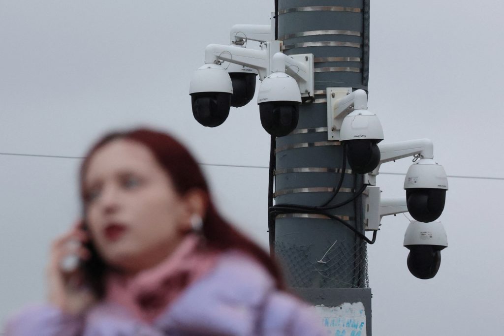 Photo: A woman talks on the phone with surveillance cameras in the background in Saint Petersburg, Russia October 19, 2023. Credit: REUTERS/Anton Vaganov