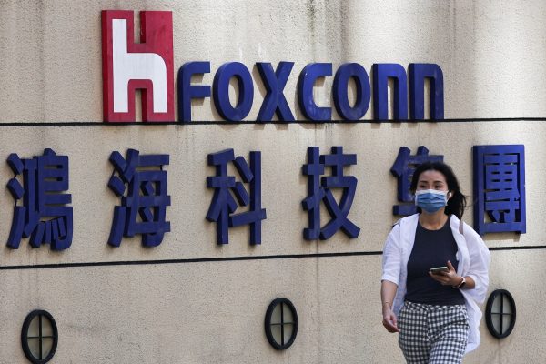Photo: A woman walks past the logo of Foxconn outside the company's building in Taipei, Taiwan November 9, 2022. Credit: REUTERS/Ann Wang/File Photo.