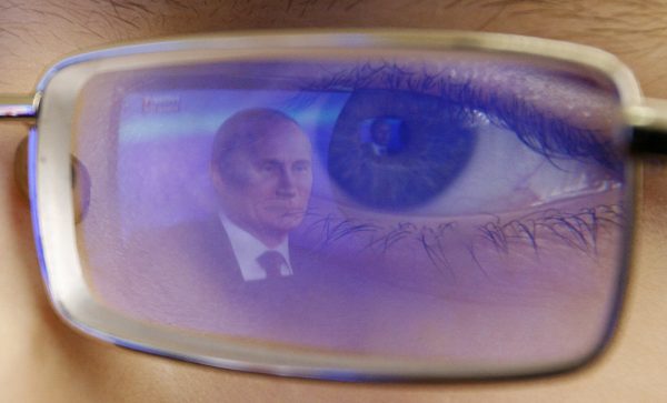 Photo: Russian President Vladimir Putin is reflected in the glasses of a cadet watching Putin's annual news conference on TV at the cadet school outside the southern Russian city of Rostov-on-Don December 20, 2012. Putin said on Thursday a U.S. law that punishes Russians who abuse human rights was poisoning ties with Washington but signalled support for a retaliatory ban on Americans adopting Russian children. Credit: REUTERS/Vladimir Konstantinov (RUSSIA - Tags: POLITICS MILITARY TPX IMAGES OF THE DAY)