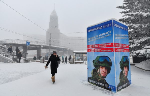 Photo: A pedestrian walks past a board, which encourages volunteers to sign a contract and serve in the Russian army, on a frosty day in the Siberian city of Krasnoyarsk, Russia, December 12, 2023. Credit: REUTERS/Alexander Manzyuk