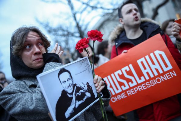 Photo: A woman reacts as she holds flowers and a picture of Russian opposition leader Alexei Navalny as she attends a vigil held in front of Russian embassy in Berlin after his death, Germany, February 16, 2024. Credit: REUTERS/Liesa Johannssen