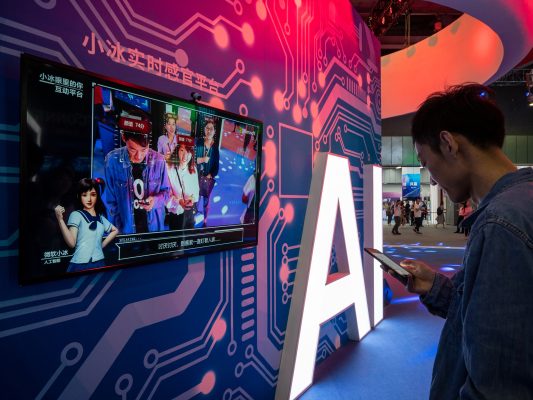Photo: A signage of Artificial Intelligence (AI) is seen at the stand of Xiaomi during the 2018 China Mobile Global Partner Conference in Guangzhou city, south China's Guangdong province, 7 December 2018. Credit: Li Zhihao/Oriental Image.