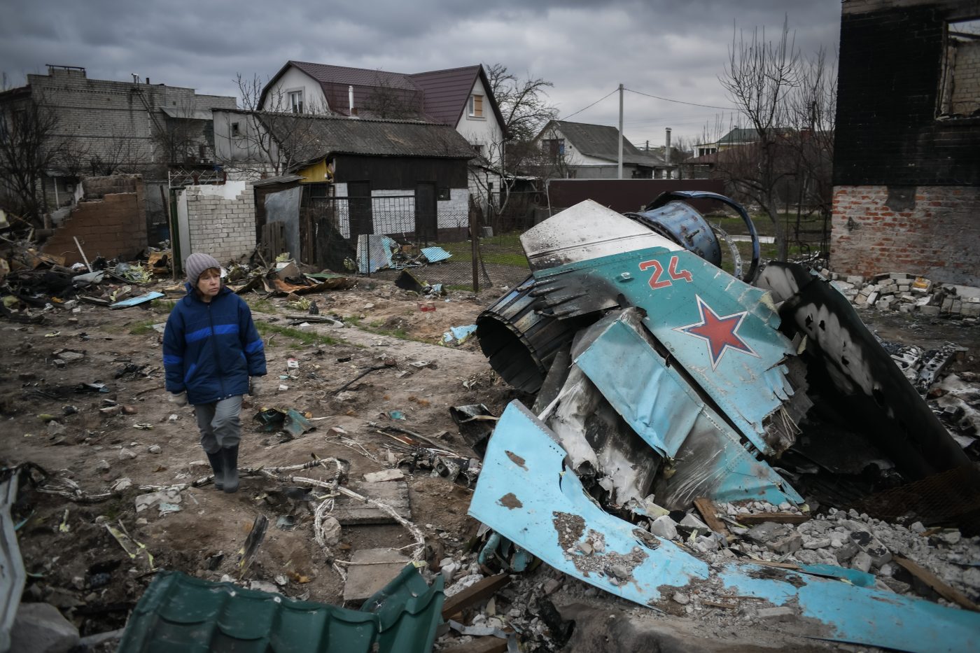 Photo: A woman walks on rubbles on the site where a destroyed Russian Sukhoi Su-34 crashed on a residential area of Chernihiv, Ukraine on April 16, 2022. The pilot managed to eject and was captured, his navigator has been killed. Russian military forces entered Ukraine territory on Feb. 24, 2022. Credit: Piero Cruciatti/Sipa USA.