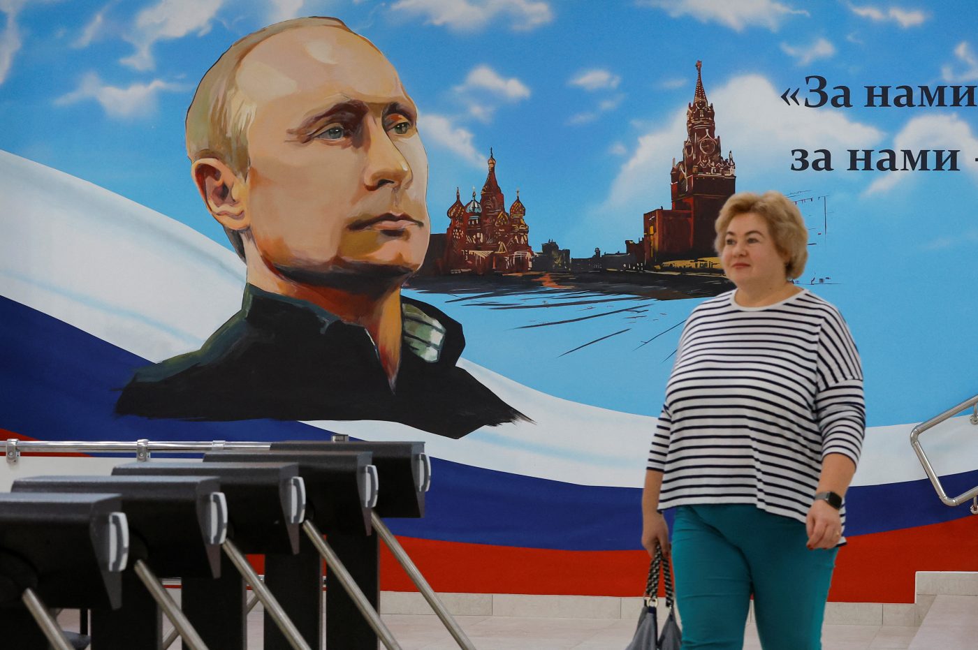 Photo: A woman walks near a mural depicting Russian President Vladimir Putin, St. Basil's Cathedral and the Moscow Kremlin's Spasskaya Tower at a polling station during local elections held by the Russian-installed authorities in the course of Russia-Ukraine conflict in Donetsk, Russian-controlled Ukraine, September 8, 2023. Credit: REUTERS/Alexander Ermochenko