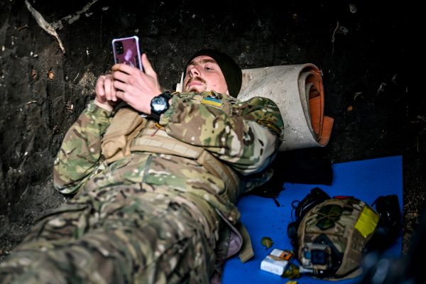 Photo: UKRAINE - NOVEMBER 3, 2022 - A serviceman of the Ukrainian Armed Forces who guards the Zaporizhzhia direction browses his phone in a dugout, Ukraine. Credit: Dmytro Smolienko/NurPhoto via Reuters Connect