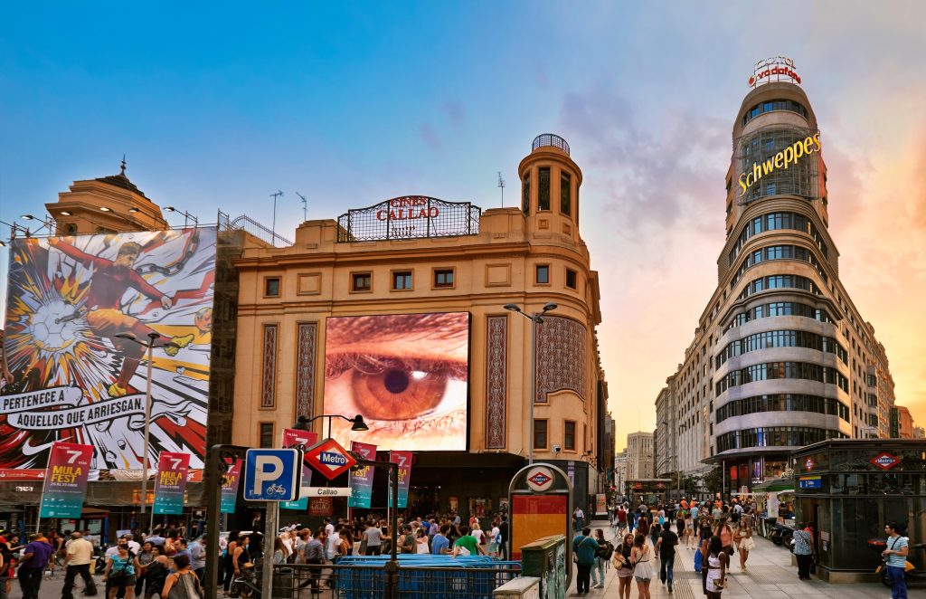 Photo: Digital screen and passersby on Plaza del Callao, Madrid, Spain. (November 12, 2014).
Credit: Factofoto via Alamy.