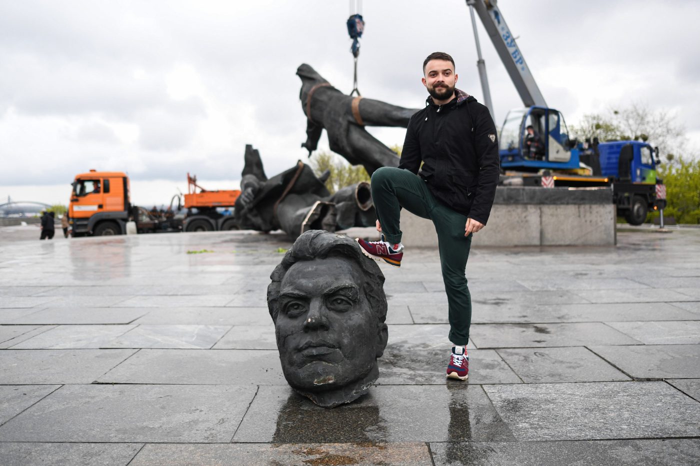 Photo: A man poses for photos while stepping on the dismantled Soviet Union monument. On April 25, 2022, Kyiv mayor Vitali Klitschko announced the removal of the Soviet Union monument in Central Kyiv. This monument erected in 1982 as a symbol of the reunification of Ukraine and Russia during the Soviet government era. The statue of two men holding a medal represents the Soviet Union's Order of Friendship of Peoples, while the rainbow-like arch is called The People's Friendship Arch. Additionally, some streets linked to Russia would be renamed. Credit: Salvatore Cavalli / SOPA Images/Sipa USA