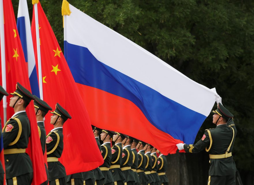Photo: A military officer adjusts a Russian flag ahead of a welcome ceremony hosted by Chinese President Xi Jinping for Russian President Vladimir Putin outside the Great Hall of the People in Beijing, China June 8, 2018. Credit: REUTERS/Jason Lee