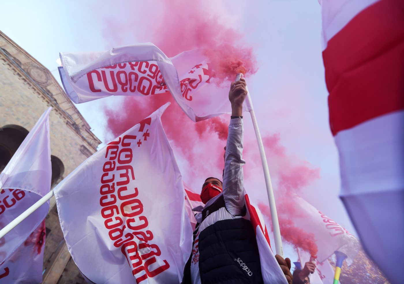 Photo: An opposition supporter holds a flare during a rally against the results of a parliamentary election in Tbilisi, Georgia November 8, 2020. Credit: REUTERS/Irakli Gedenidze