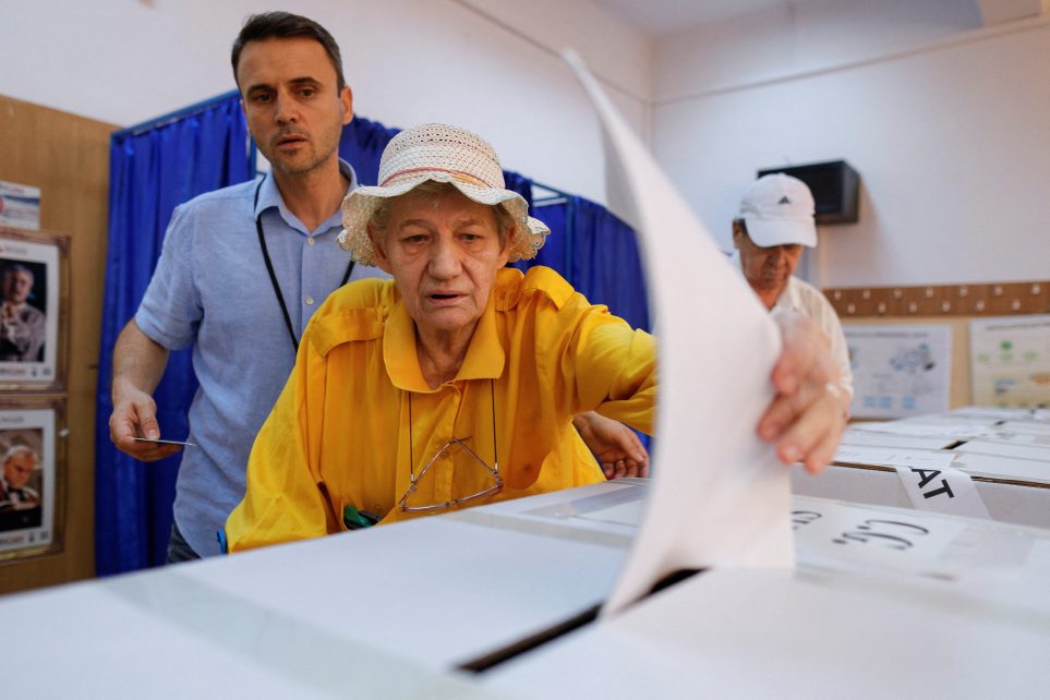 Photo: A woman is assisted by a member of the committee to cast her vote for the European Parliament election and the local elections, in Bucharest, Romania, 9 June 2024. Credit: Inquam Photos/Octav Ganea via REUTERS