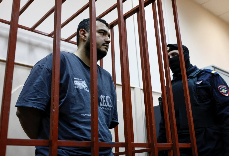 Photo: A detainee, named as Uzbek national Akhmad Kurbanov and considered by investigators as a suspect in the murder of chief of Russia's Nuclear, Biological and Chemical Protection Troops Igor Kirillov along with his assistant, stands inside an enclosure for defendants as he attends a court hearing in Moscow, Russia December 19, 2024. Credit: REUTERS/Yulia Morozova