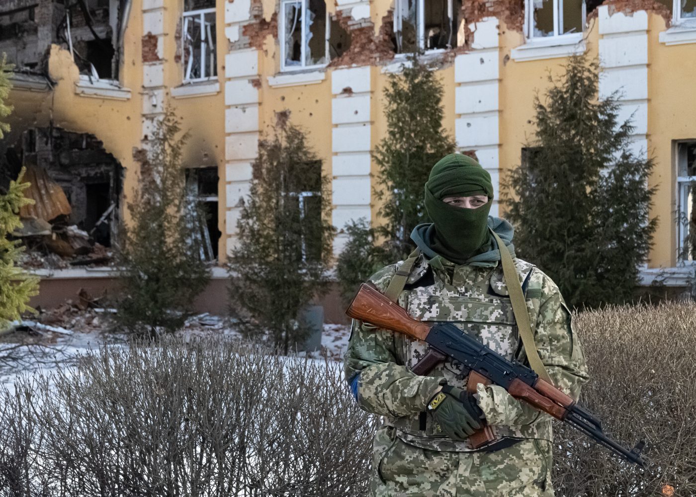 Photo: A Ukriainan Soldier in front of Specialized School 134 in Kharkiv, Ukraine on Mar. 17, 2022. The school caught fire after being shelled by Russian forces. Credit: Collin Mayfield/Sipa USA via Reuters