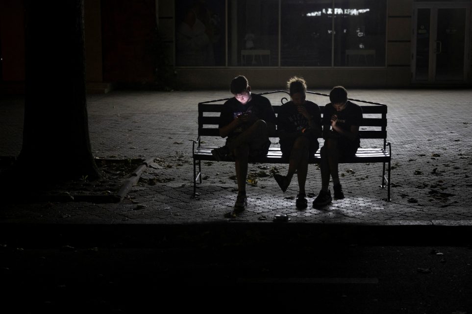 Photo: People use their phones in a poorly lit street during an electricity blackout in Mykolaiv, Ukraine, amid Russia's attack on Ukraine, July 4, 2024. Credit: REUTERS/Thomas Peter